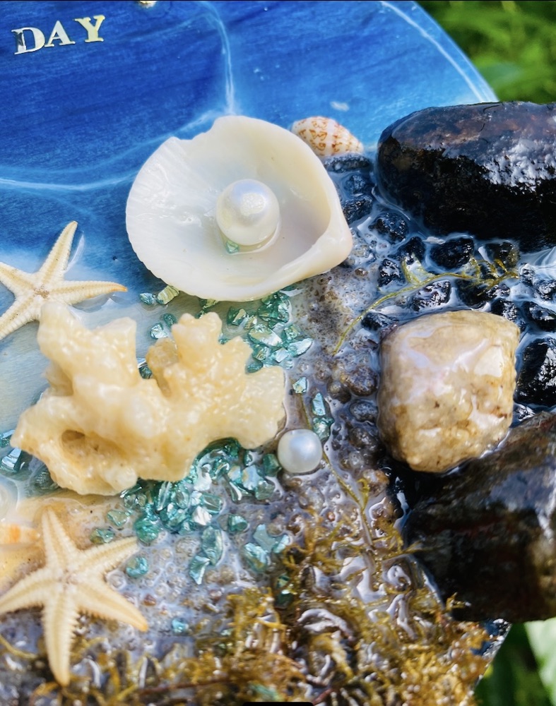 Close-up detail of a resin piece with starfish, coral and pearls